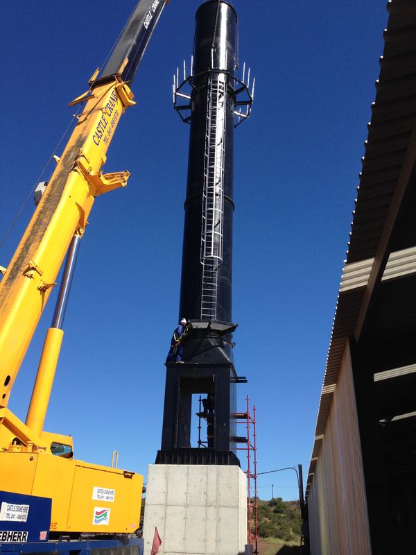 Crane lifting a black exhaust stack